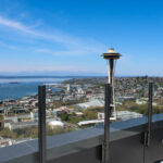Glass railing on Spire Seattle's rooftop patio with a view of the Space Needle