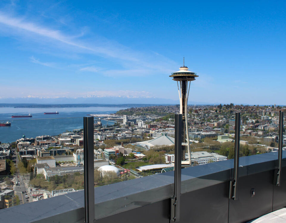 Glass railing on Spire Seattle's rooftop patio with a view of the Space Needle