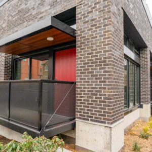 Metal railings with sun shade and balconies on first level apartments