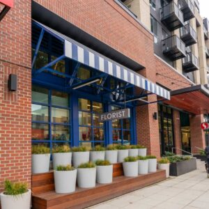 Glass railing on balconies of multifamily apartment complex along with metal awnings