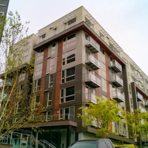 Sun shade around the top level of an apartment complex along with framed glass railings on balconies