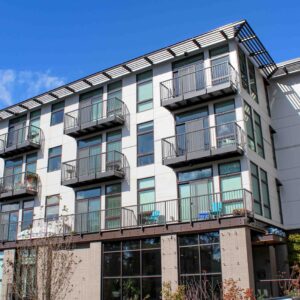 Sun shade around the top level of an apartment complex along with vertical picket railings on balconies